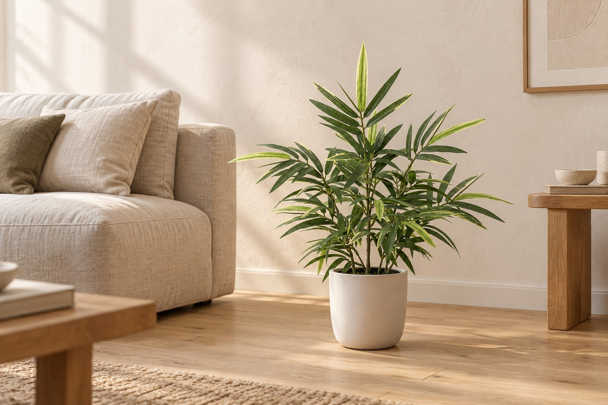 Kunstplant Bamboe van 57 cm in een witte keramische pot in een lichte woonkamer