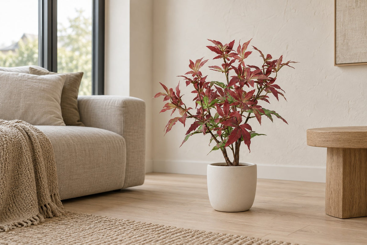 Kunstplant Esdoorn van 53 cm in een witte keramische pot in een lichte woonkamer