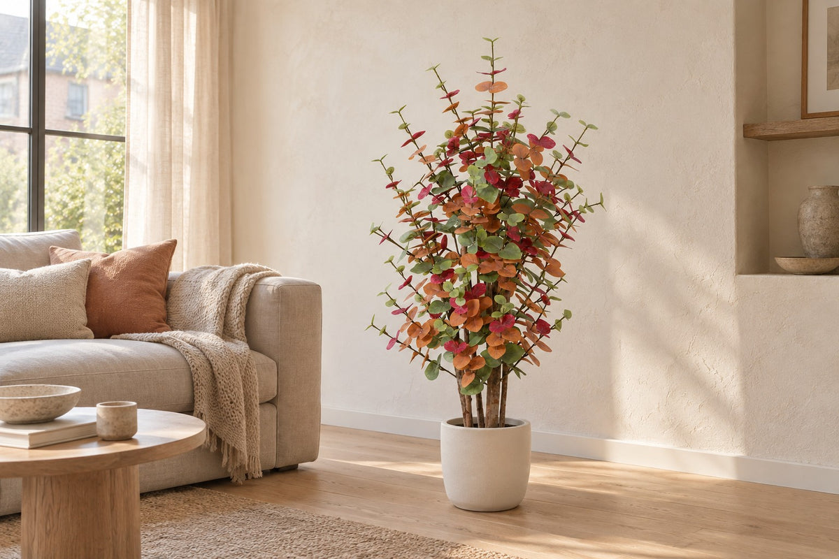 Kunstplant Eucalyptus gekleurd van 120 cm in een witte keramische pot in een lichte woonkamer