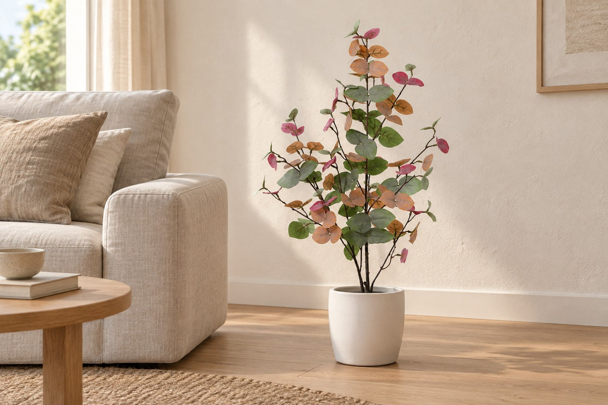 Pianta artificiale Eucalyptus colorato, 86 cm, in a white ceramic planter in un soggiorno luminoso
