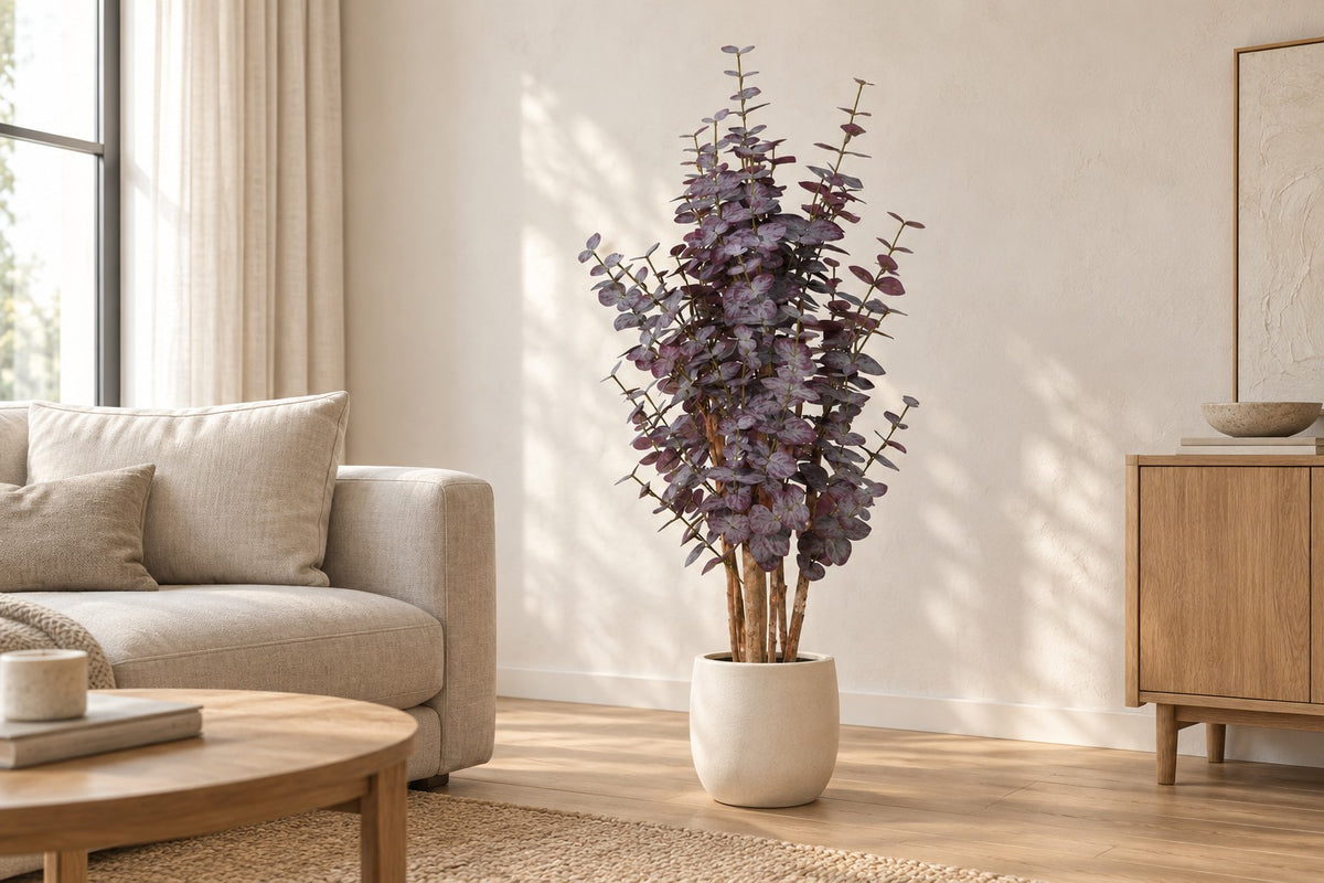 Pianta artificiale Eucalyptus viola, 120 cm, in a white ceramic planter in un soggiorno luminoso