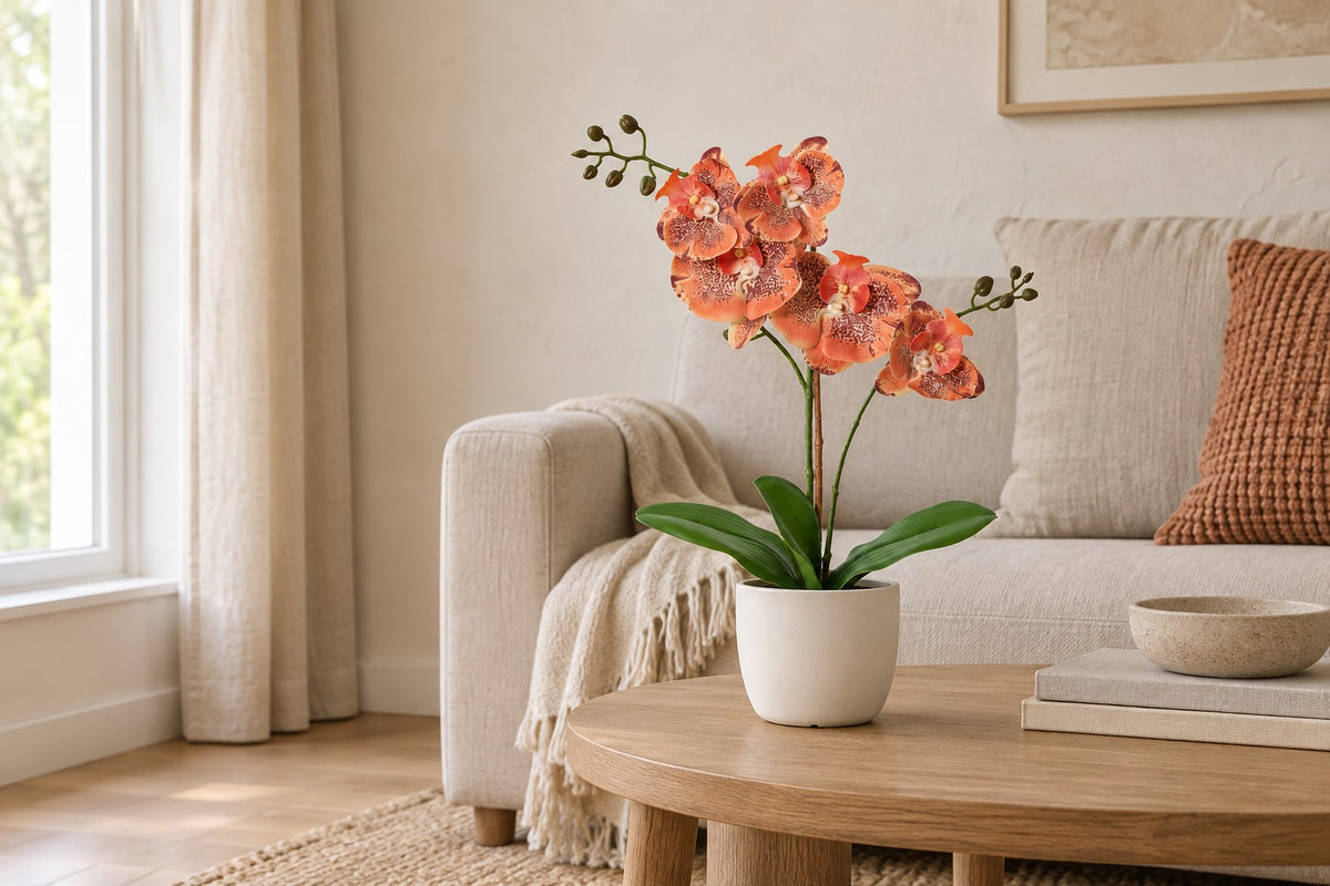 Orquídea Phalaenopsis artificial naranja, 42 cm, en a white ceramic planter en un salón luminoso