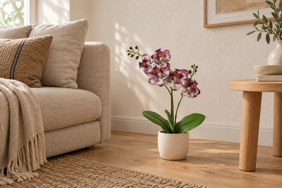 Kunstplant Phalaenopsis Orchidee paars van 41 cm in een witte keramische pot in een lichte woonkamer