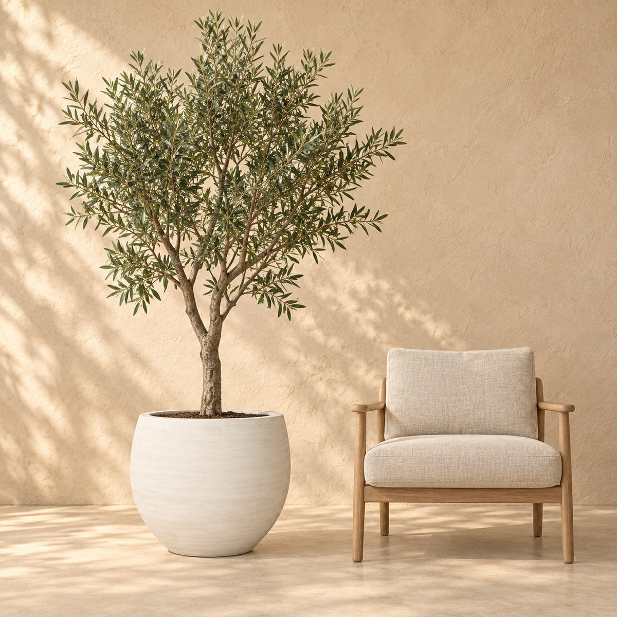 Ziertopf Orb Ivory Washed Ø69 x H57 cm, in Originalgröße neben einem Sessel