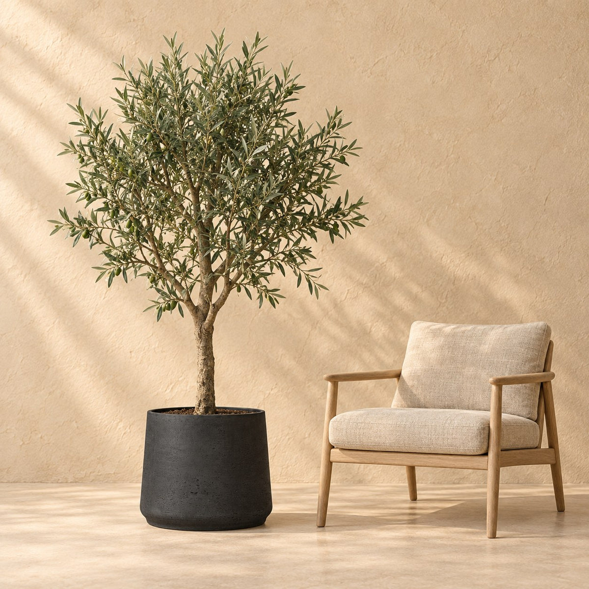 Sierpot Patt Black Washed Ø45 x H38 cm, op ware grootte naast een fauteuil